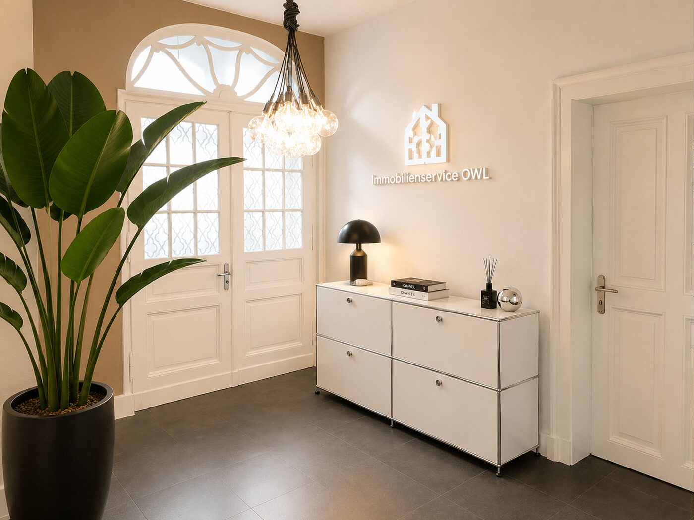 Empfangsbereich mit Backsteinwand und beleuchtetem Markenzeichen bei Immobilienservice OWL