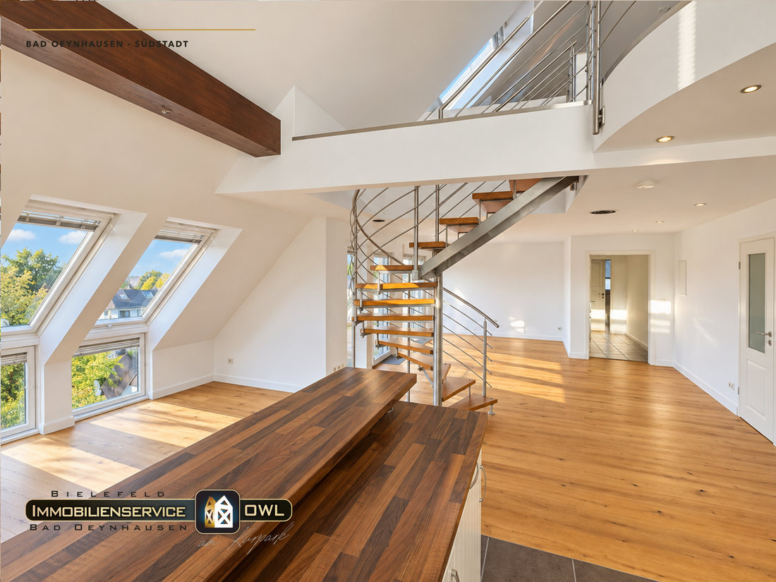 Wohnraum mit sichtbarem Holzbalken unter der Galerie