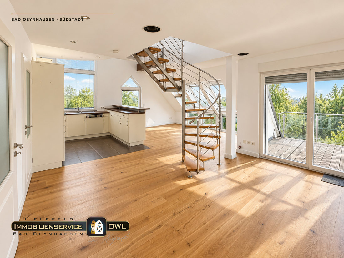 Wohn- und Essbereich mit der frei stehenden Edelstahl-Wendeltreppe und Zugang zum Balkon